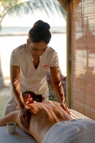 a woman giving a woman a back massage at Ambre - Adults only in Belle Mare
