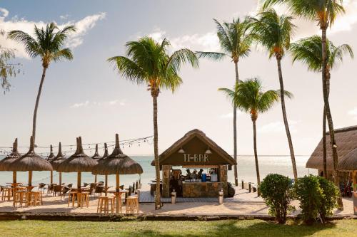 a restaurant on the beach with palm trees at Ambre - Adults only in Belle Mare