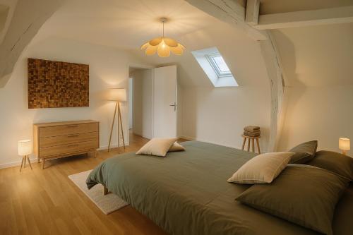 a bedroom with a large bed and a skylight at La maison du canal in Champforgeuil