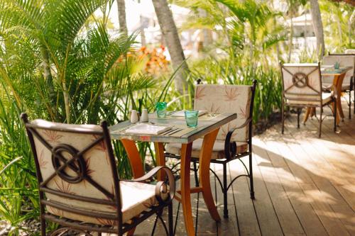 a wooden table and chairs on a patio at Ambre - Adults only in Belle Mare