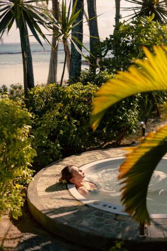 a woman in a swimming pool on the beach at Ambre - Adults only in Belle Mare