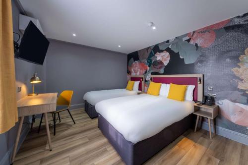 a hotel room with two beds and a desk at Comfort Inn Edgware Road W2 in London