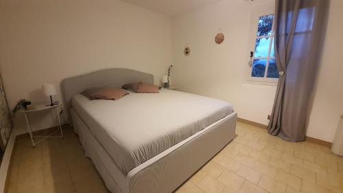 - un lit blanc dans une chambre avec fenêtre dans l'établissement Cocon de Provence, au Cannet-des-Maures