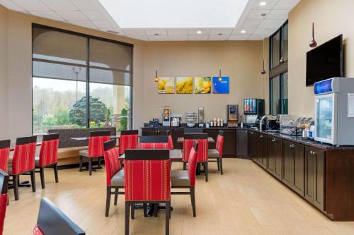 ein Restaurant mit einer Bar mit roten Stühlen und einer Theke in der Unterkunft Comfort Inn North of Asheville in Mars Hill