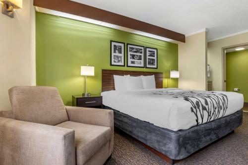 a hotel room with a bed and a chair at Sleep Inn Matthews-Charlotte in Charlotte