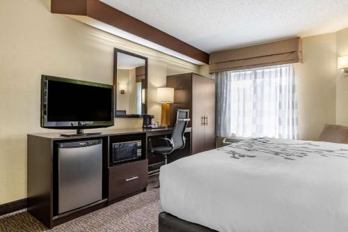 a hotel room with a bed and a flat screen tv at Sleep Inn Matthews-Charlotte in Charlotte