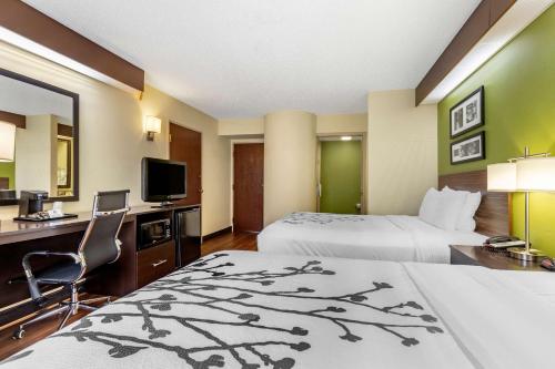 a hotel room with two beds and a desk with a computer at Sleep Inn Matthews-Charlotte in Charlotte