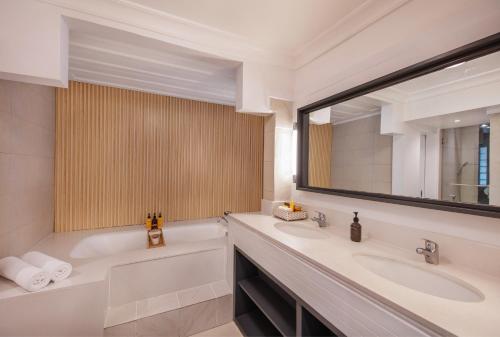 a bathroom with two sinks and a tub and a mirror at Ambre - Adults only in Belle Mare
