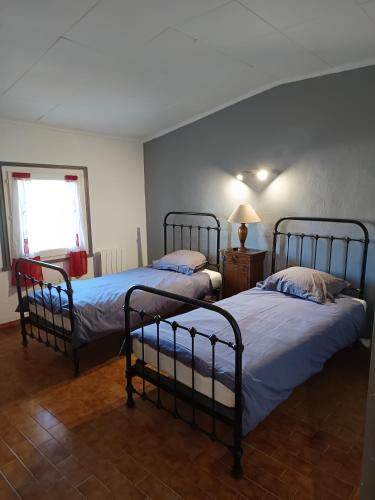 une chambre avec deux lits et une fenêtre dans l'établissement appartement de village 2nd étage, à Malaucène