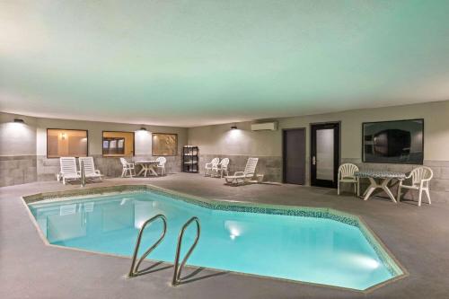 a large pool with chairs and a table at Baymont by Wyndham Moses Lake in Moses Lake