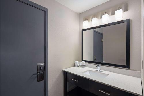 a bathroom with a sink and a mirror at Baymont by Wyndham Moses Lake in Moses Lake