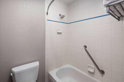 a bathroom with a toilet and a tub and a sink at Baymont by Wyndham Moses Lake in Moses Lake