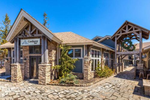a home with a stone driveway in front of a building at Corduroy Inn and Lodge, Trademark Collection by Wyndham in Snowshoe