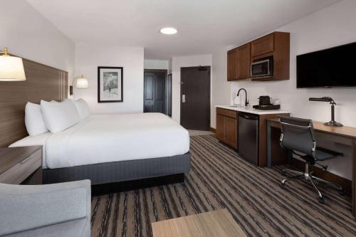 a hotel room with a large bed and a kitchen at Corduroy Inn and Lodge, Trademark Collection by Wyndham in Snowshoe