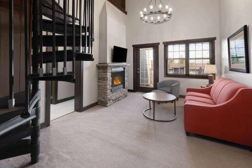 a living room with a red couch and a fireplace at Corduroy Inn and Lodge, Trademark Collection by Wyndham in Snowshoe