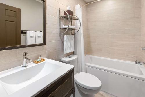 a bathroom with a sink and a toilet and a tub at Corduroy Inn and Lodge, Trademark Collection by Wyndham in Snowshoe