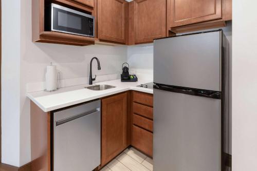 a small kitchen with a refrigerator and a sink at Corduroy Inn and Lodge, Trademark Collection by Wyndham in Snowshoe