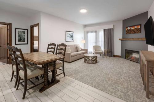 a living room with a table and a couch and a fireplace at Corduroy Inn and Lodge, Trademark Collection by Wyndham in Snowshoe