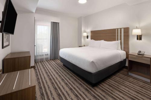a hotel room with a bed and a television at Corduroy Inn and Lodge, Trademark Collection by Wyndham in Snowshoe