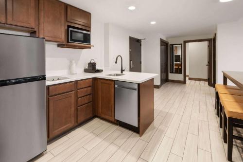 a kitchen with wooden cabinets and a white counter top at Corduroy Inn and Lodge, Trademark Collection by Wyndham in Snowshoe
