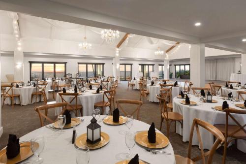 a banquet hall with white tables and chairs at Corduroy Inn and Lodge, Trademark Collection by Wyndham in Snowshoe