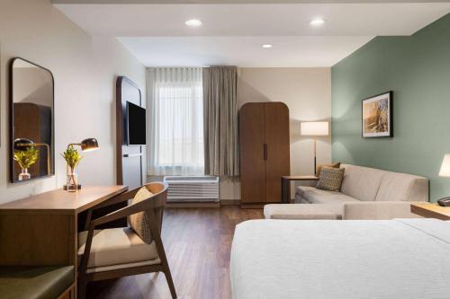 a hotel room with a bed and a couch at La Quinta Inn and Suites by Wyndham Lincoln in Lincoln
