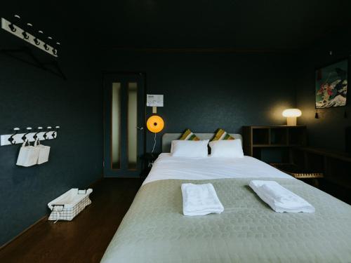 a bedroom with a large white bed with towels on it at 大正車站4分陽当たり良い貸切一軒家 in Osaka
