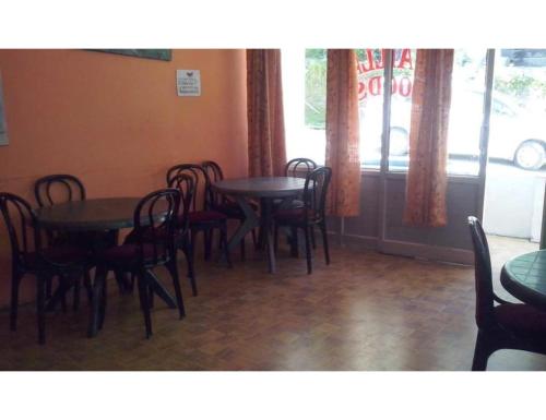 a dining room with tables and chairs and a window at Hotel Kamet, Joshimath in Joshīmath