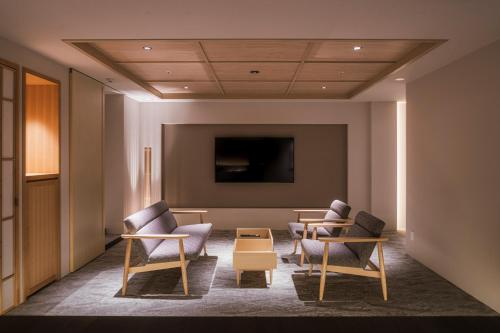 a waiting room with chairs and a flat screen tv at Shinzan Kinosaki in Toyooka