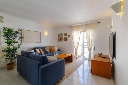 a living room with a blue couch and a table at Casa Maisie Apartment in Burgau