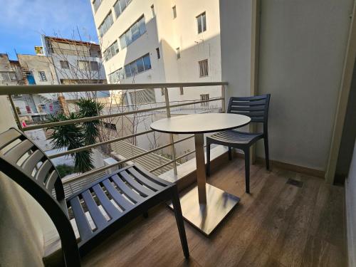 a table and two chairs on a balcony with a view at Silk Suites by YHA in Athens
