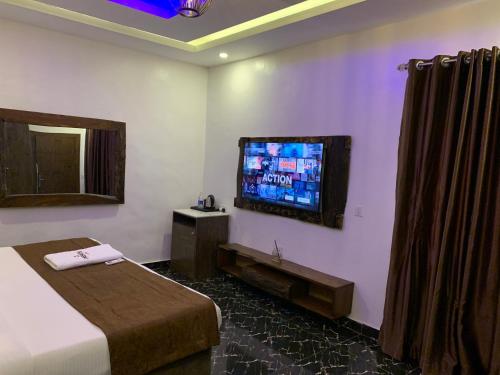 a hotel room with a bed and a flat screen tv at Presken Kuramo Waters in Lagos