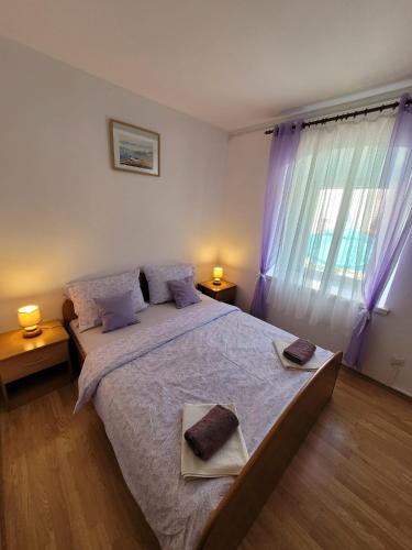 a bedroom with a large bed with two towels on it at Malin Guesthouse in Skradin