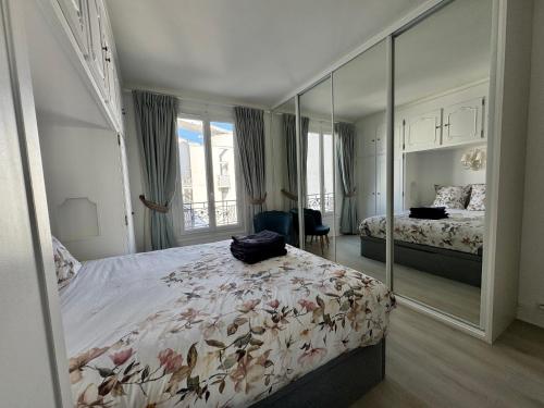 une chambre avec deux lits et un grand miroir dans l'établissement Appartement 2 pièces élégant proche Porte de Versailles, à Paris