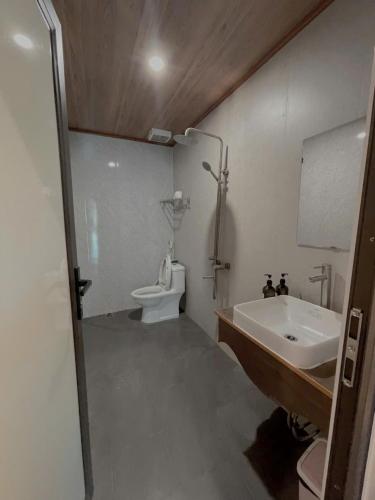 a bathroom with a tub and a sink and a toilet at BG Stone Homestay in Mộc Châu