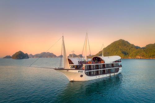 a boat in the water with mountains in the background at Sena Cruises - Wonder On Lan Ha Bay in Ha Long