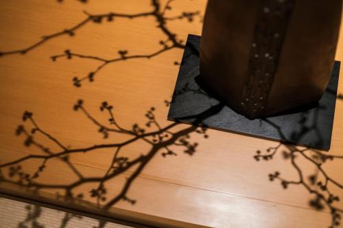 a branch of a plant on a wooden table at Shinzan Kinosaki in Toyooka