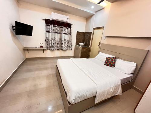 a small bedroom with a bed and a television at HARI STAYs in Tirupati