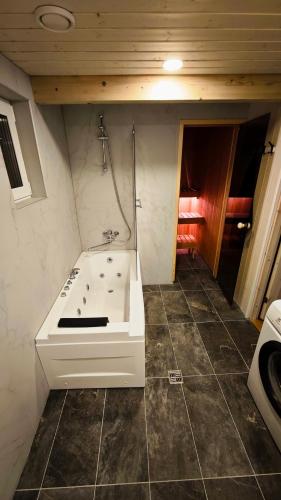 a bathroom with a bath tub and a sink at White Nights holiday home with sauna and grill in Pärnu