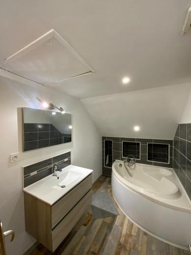 La salle de bains est pourvue d'une grande baignoire blanche et d'un lavabo. dans l'établissement Bed and breakfast Countryside, donkeys goats, à Courgains