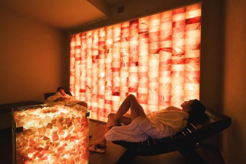 a person laying in a chair in front of a window at Sardegna Termale Hotel&SPA in Sardara