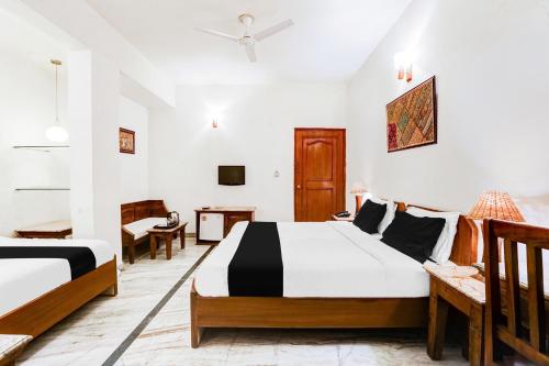 a hotel room with two beds and a desk at Hotel O Sansarchandra Road Formerly Luna Rosa in Jaipur