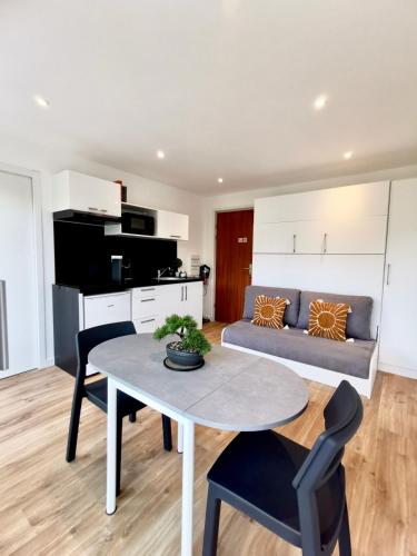 un salon avec une table et un canapé dans l'établissement L'Azur - 50 m de la Plage, Wi-Fi, Moderne, Central, à La Baule