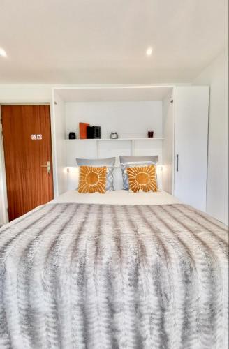 - une chambre blanche avec un grand lit et des oreillers orange dans l'établissement L'Azur - 50 m de la Plage, Wi-Fi, Moderne, Central, à La Baule