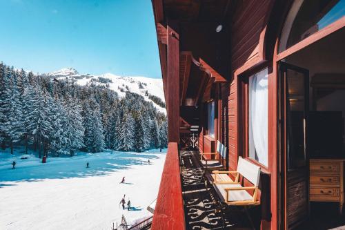 a balcony of a building with a snow covered mountain at Hotel Carlina in Courchevel