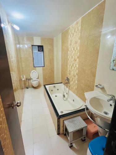 a bathroom with a tub and a toilet and a sink at Taj Villa with free Wifi in Lonavala