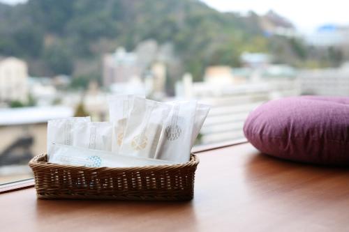 a basket filled with white tissues on a table next to a window at Arima Kirari in Kobe