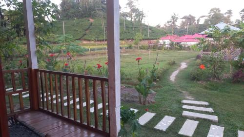 a balcony with a view of a yard with a garden at Oronner Dinratri in Sreemangal
