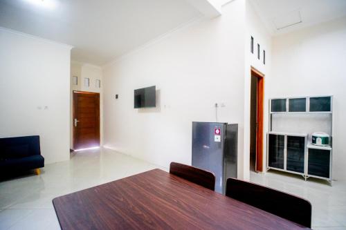a dining room with a table and a refrigerator at Griya Godean Homestay Jogja in Godean