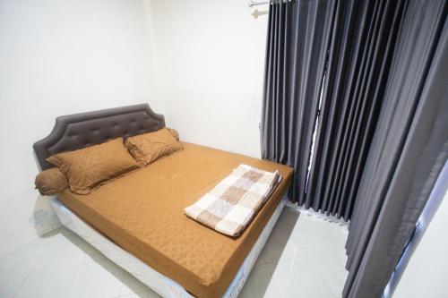 a small bed in a room with a window at Griya Godean Homestay Jogja in Godean